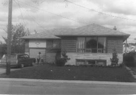 brick bungalow with station wagon 1960s, young woman with child